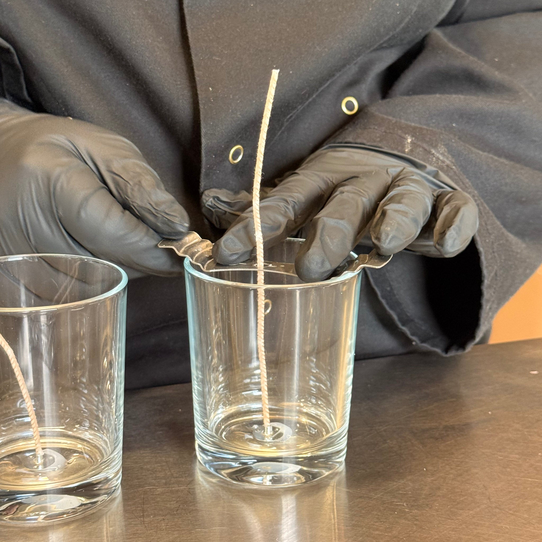 Mèches centrées dans des pots en verre vides grâce aux centreurs de mèche en acier inoxydable