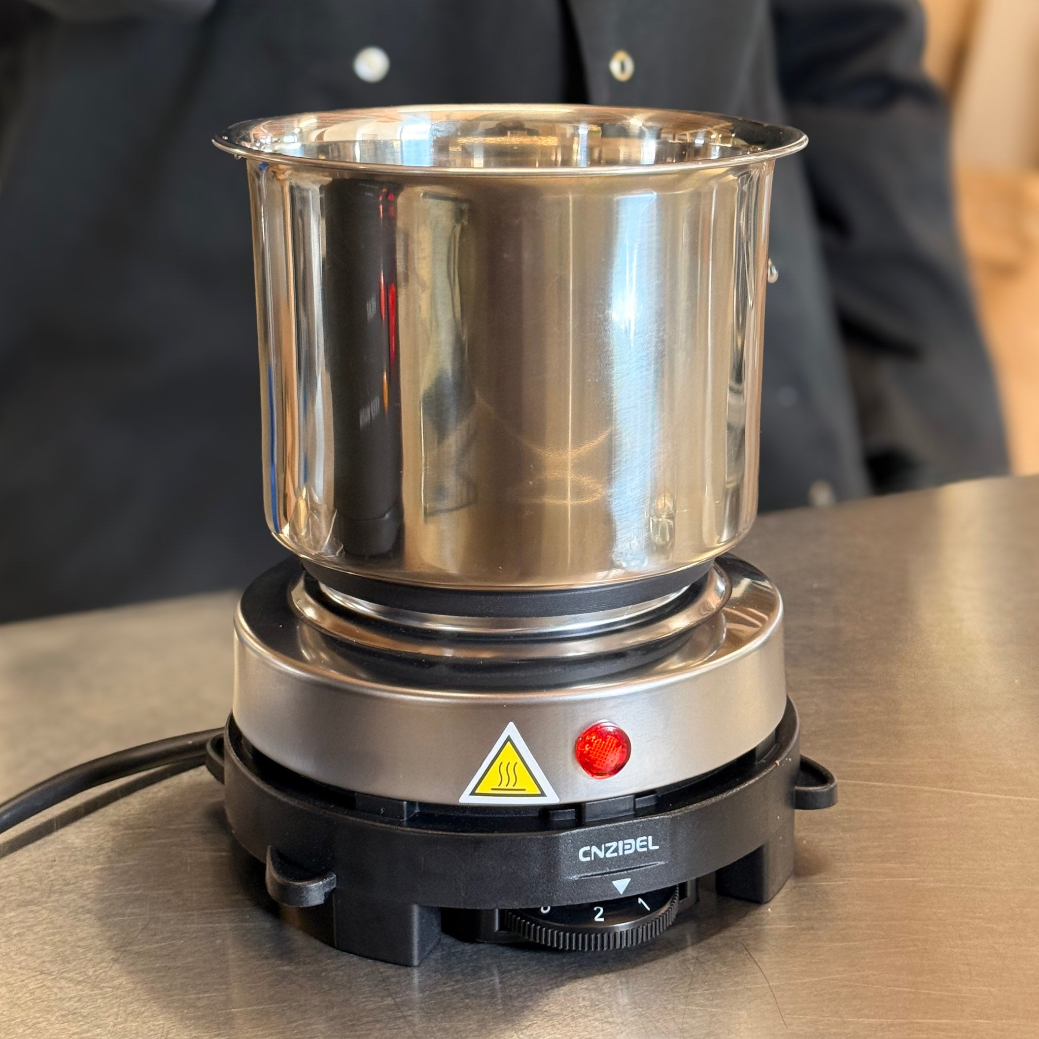 Plaque chauffante électrique avec pot de fusion en acier posé dessus - fabrication de bougies